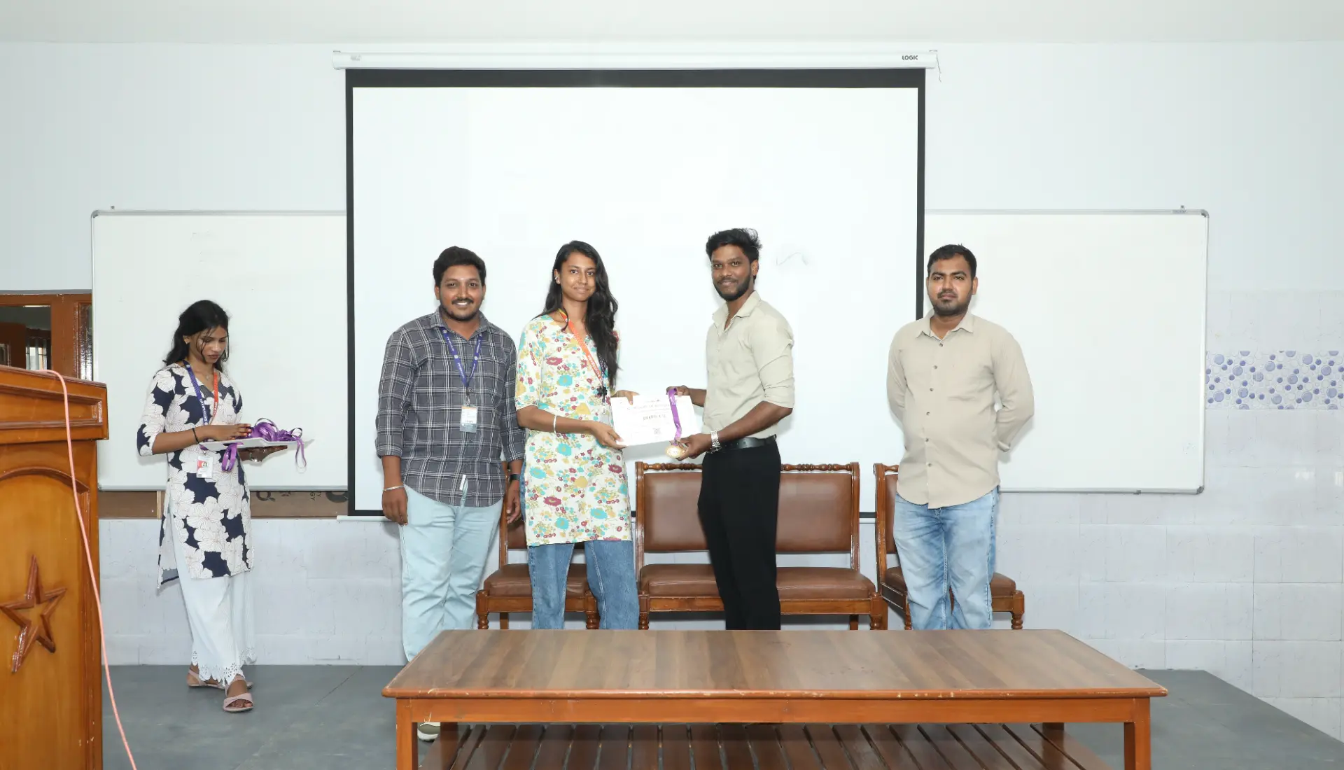 A student receiving a certificate and award at the B2E campus program ceremony