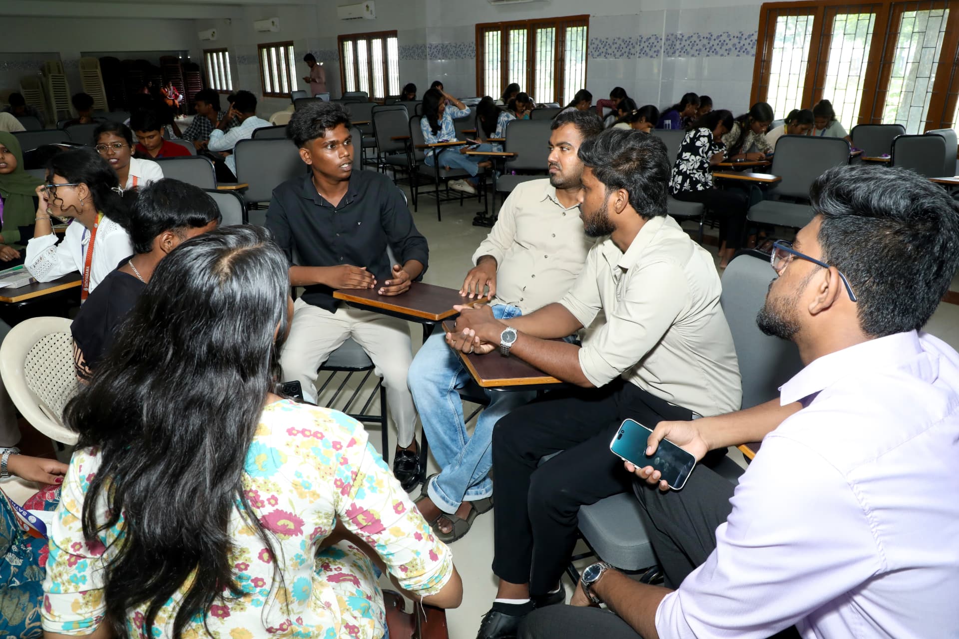 B2E mentors discussing a business idea with students in a small group
