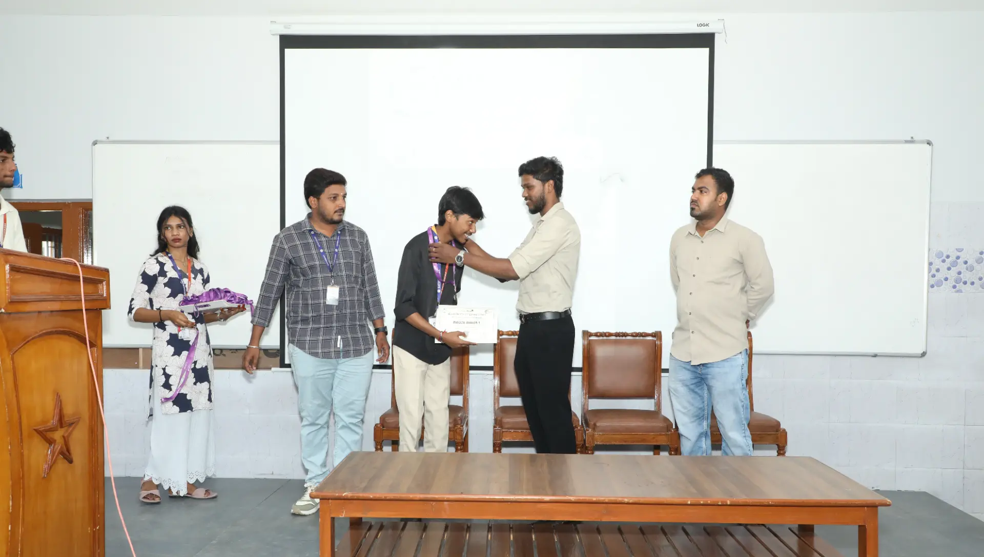 A student receiving a certificate and medal during the B2E campus program